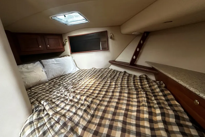 Slide: The Image of Cozy cabin interior of 2003 Rampage 38 Express with plaid bedding and wooden cabinets. - 8