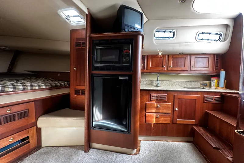 Slide: The Image of 2003 Rampage 38 Express cabin interior with kitchenette, bed, and storage cabinets. - 9