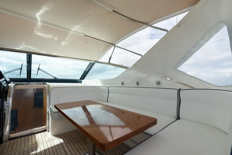 Slide: The Image of Luxurious interior of 2001 Uniesse 48 Open yacht with white seating and wooden table. - 10
