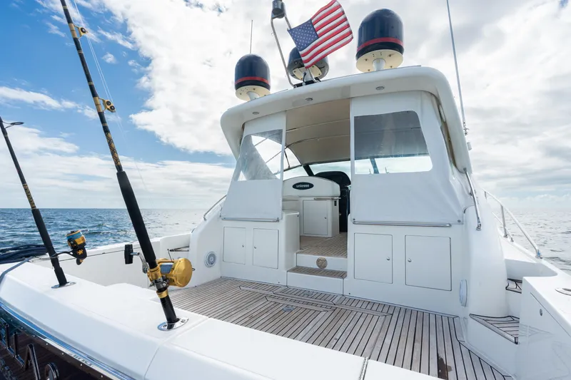 Slide: The Image of 2001 Uniesse 48 Open yacht with fishing rods and American flag on deck. - 23