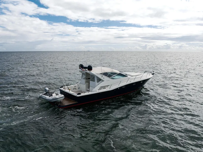 Slide: The Image of 2001 Uniesse 48 Open yacht cruising on open water under cloudy skies. - 30