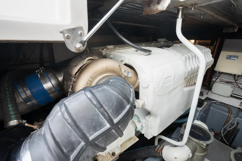 Slide: The Image of Engine compartment of 2001 Uniesse 48 Open yacht, showcasing mechanical components and piping. - 35