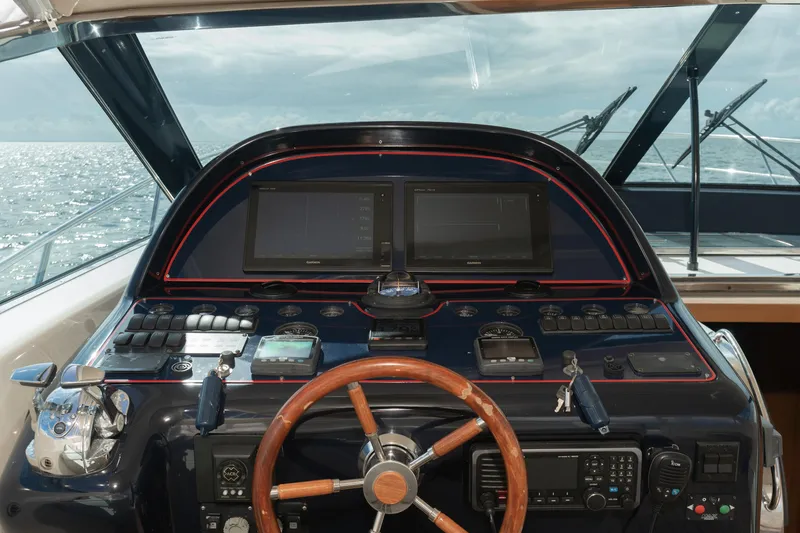 Slide: The Image of Uniesse 48 Open 2001 yacht helm with wooden steering wheel and navigation screens. - 9