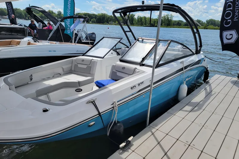 Slide: The Image of 2024 Godfrey Hurricane 235SD boat docked on a sunny day, showcasing sleek design and spacious seating. - 8