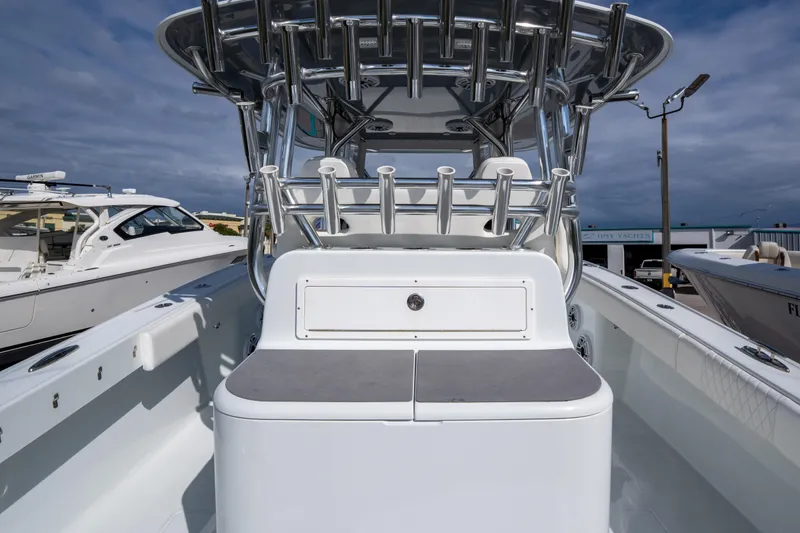 Slide: The Image of 2022 Freeman 34 boat interior with rod holders and seating, docked under cloudy sky. - 13