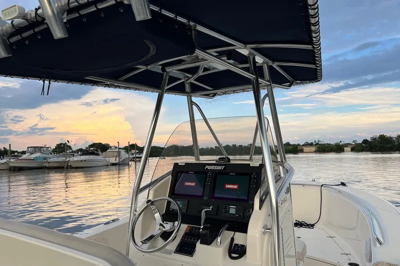 Slide: The Image of 2012 Pursuit C 230 Center Console boat on calm water at sunset. - 6