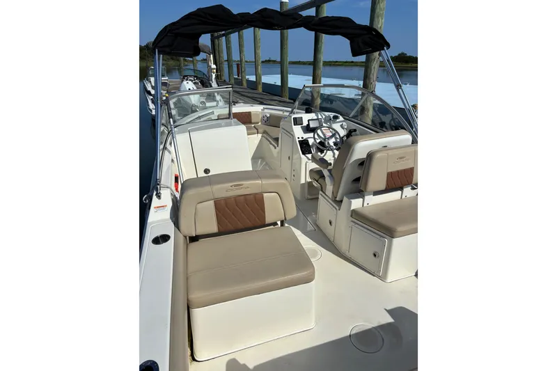 Slide: The Image of 2024 Cobia 220 Dual Console boat interior with seating and steering wheel. - 5