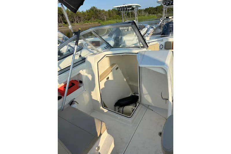 Slide: The Image of 2024 Cobia 220 Dual Console boat interior with open storage compartment. - 6