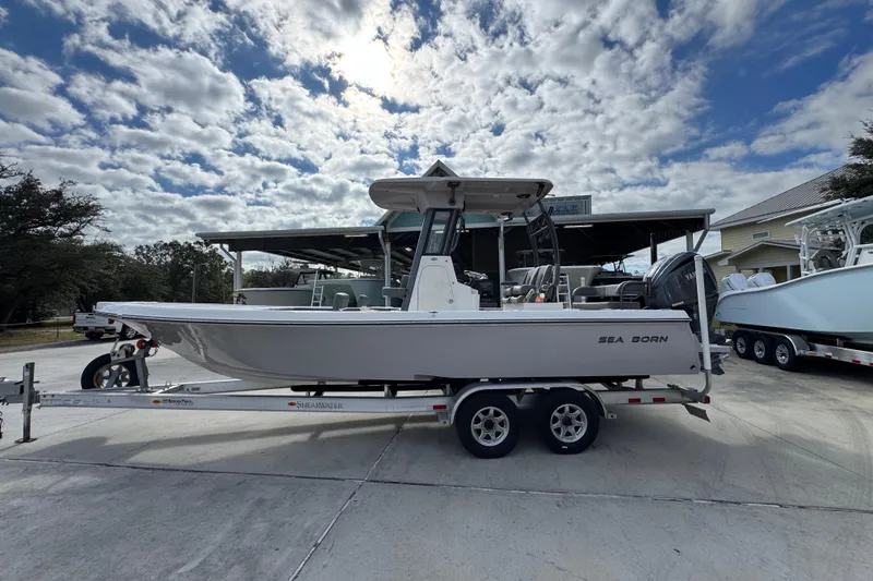The Image of 2026 Sea Born FX261 Bay boat on trailer under cloudy sky. - 1