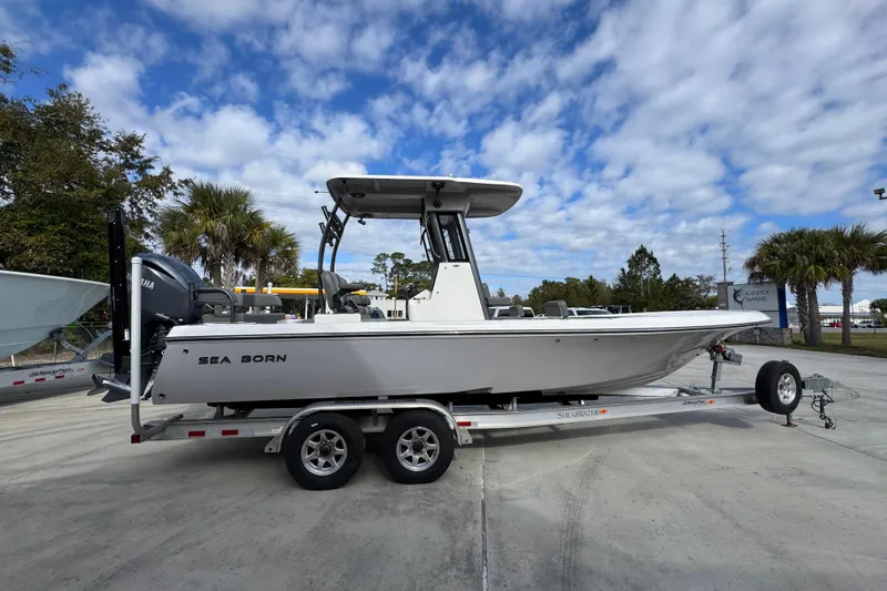 Slide: The Image of 2026 Sea Born FX261 Bay boat on trailer, parked outdoors under a cloudy sky. - 10