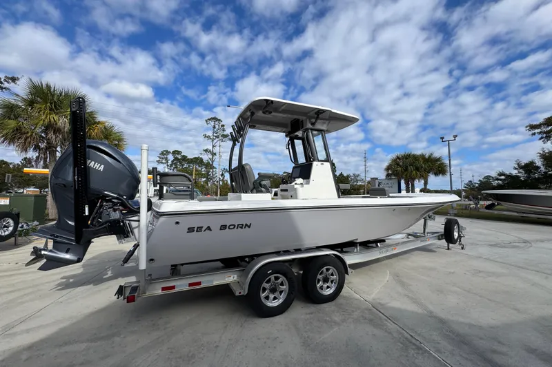 Slide: The Image of 2026 Sea Born FX261 Bay boat on trailer, parked outdoors under a cloudy sky. - 11