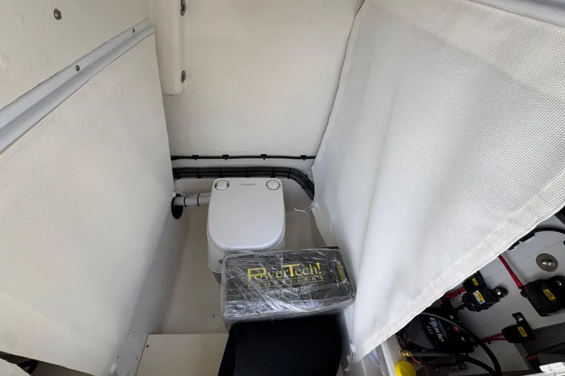 Slide: The Image of Interior of 2026 Sea Born FX261 Bay boat featuring a compact marine toilet setup. - 26