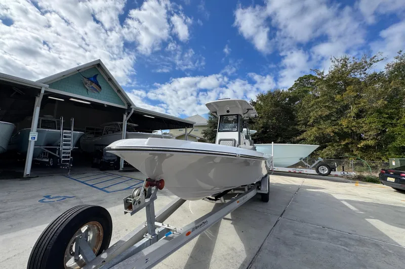 Slide: The Image of 2026 Sea Born FX261 Bay boat on trailer, parked outdoors under a partly cloudy sky. - 5