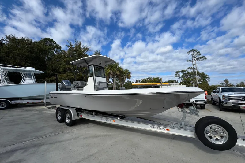 Slide: The Image of 2026 Sea Born FX261 Bay boat on trailer under blue sky. - 8