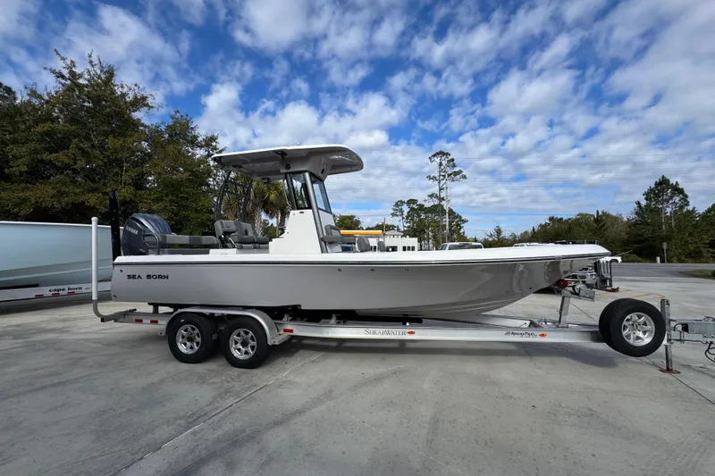 Slide: The Image of 2026 Sea Born FX261 Bay boat on trailer under a partly cloudy sky. - 9