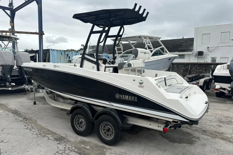Slide: The Image of 2020 Yamaha Boats 210 FSH on trailer, parked outdoors, showcasing sleek design and modern features. - 4