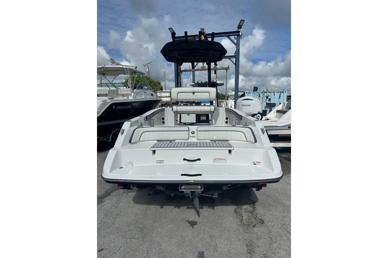 Slide: The Image of 2020 Yamaha Boats 210 FSH, rear view, docked under cloudy sky. - 9