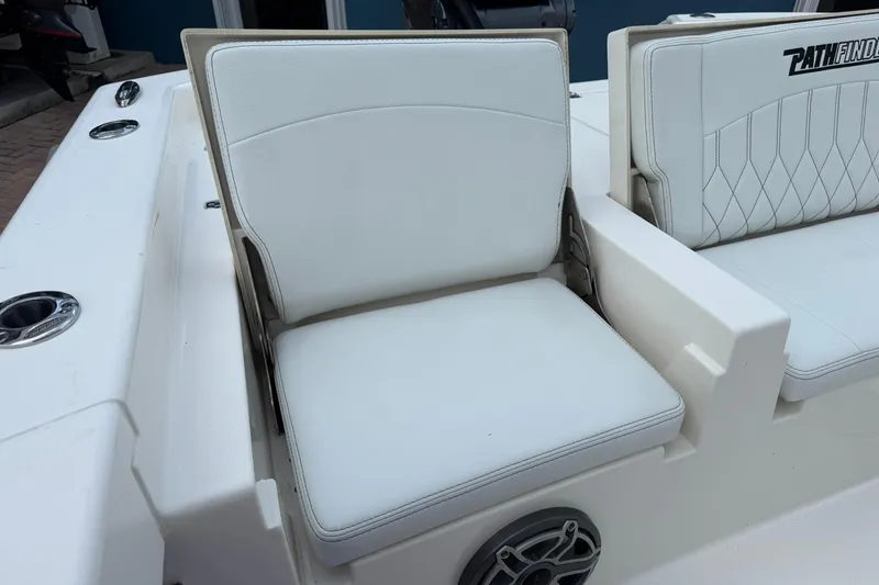 Slide: The Image of 2023 Pathfinder 2600 TRS boat seating with white cushioned seats and speaker detail. - 12