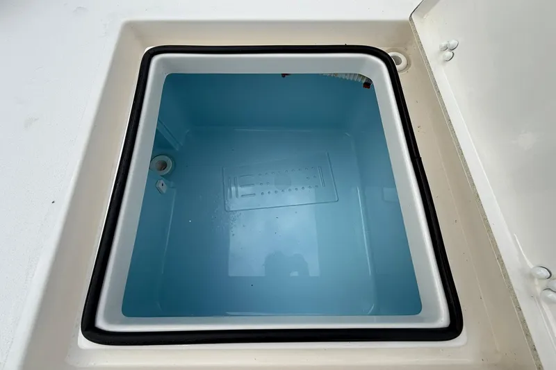 Slide: The Image of 2023 Pathfinder 2600 TRS boat storage compartment, open and empty, with a blue interior. - 18