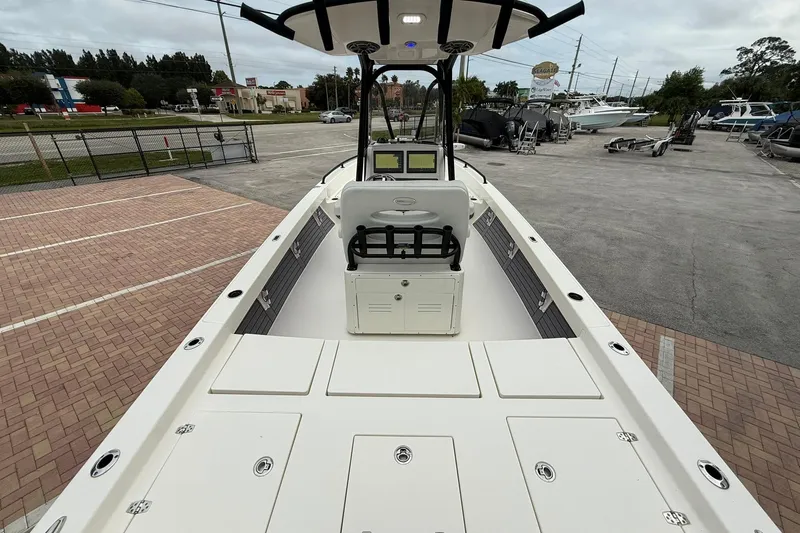 Slide: The Image of 2023 Pathfinder 2600 TRS boat interior with console and seating, parked outdoors. - 7