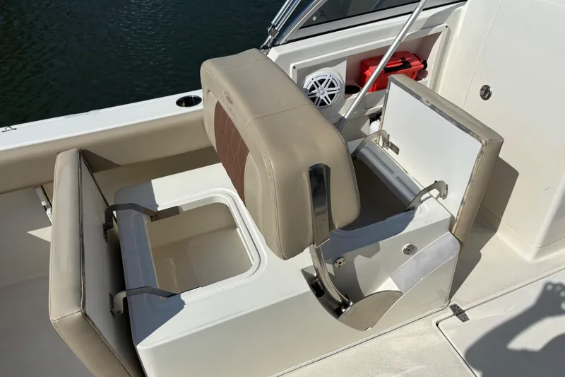 Slide: The Image of 2024 Cobia 220 Dual Console boat interior with storage compartments and seating. - 6