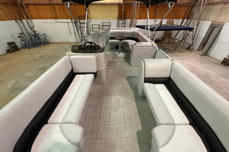 Slide: The Image of 2019 SunCatcher V22 Cruise pontoon boat interior with spacious seating in a warehouse. - 7