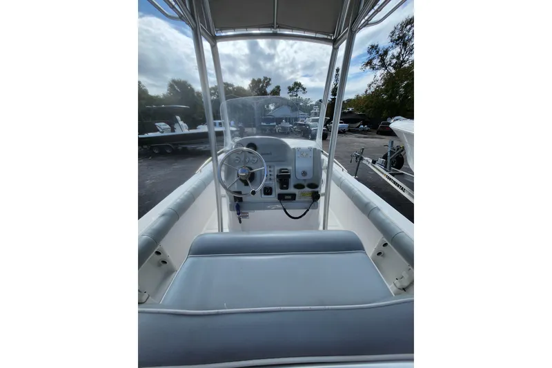 Slide: The Image of 2020 Glasstream 240 CCX boat interior with steering wheel and console, parked outdoors. - 10