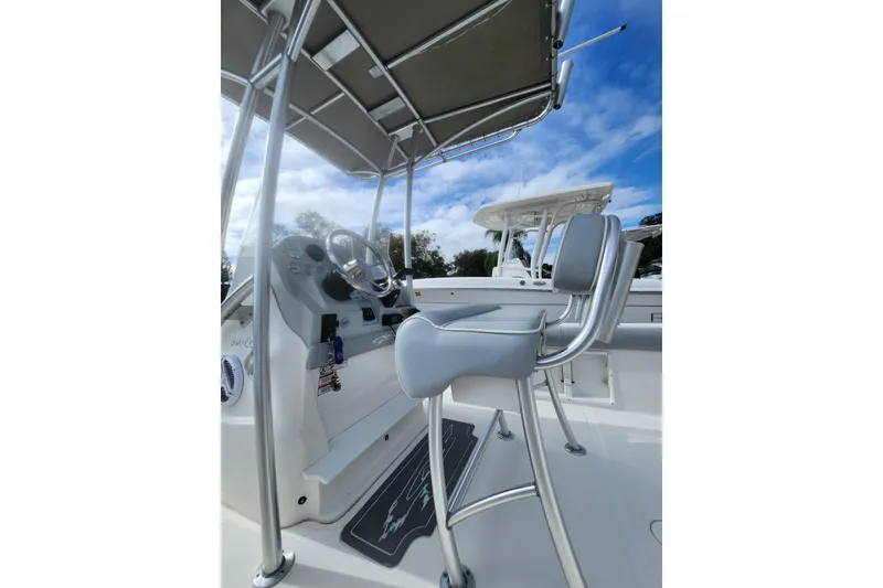 Slide: The Image of 2020 Glasstream 240 CCX boat interior with steering console and seating under canopy. - 9