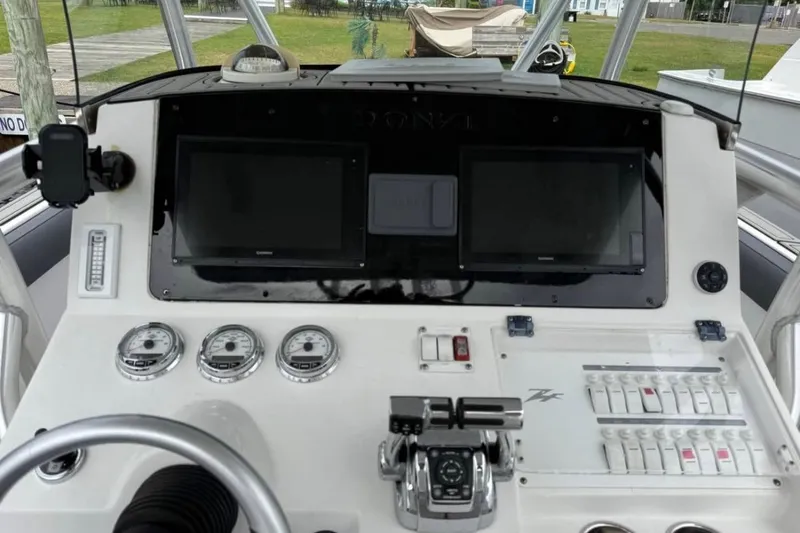 Slide: The Image of 2008 Donzi 32 ZF boat dashboard with gauges, controls, and dual screens. - 8