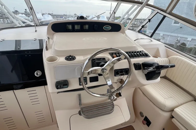 Slide: The Image of 2006 Grady-White Express 330 helm with steering wheel and control panel. - 11