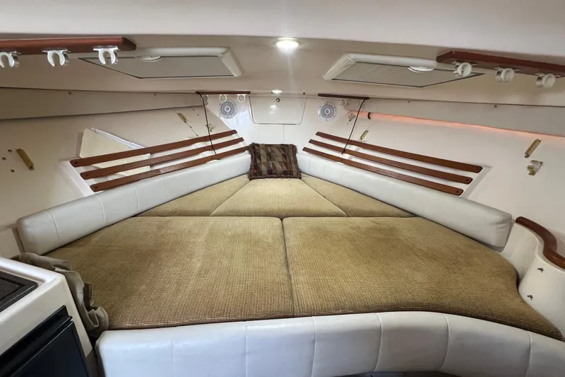 Slide: The Image of 2006 Grady-White Express 330 cabin interior with cozy sleeping area and wooden accents. - 3