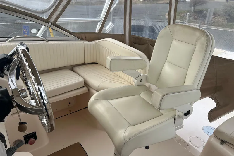 Slide: The Image of 2006 Grady-White Express 330 boat interior with cream leather seating and steering wheel. - 4