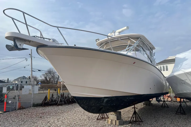 Slide: The Image of 2006 Grady-White Express 330 boat on stands, displayed outdoors under a cloudy sky. - 6