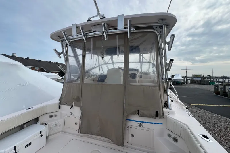 Slide: The Image of 2006 Grady-White Express 330 boat with covered cockpit, docked under cloudy sky. - 8