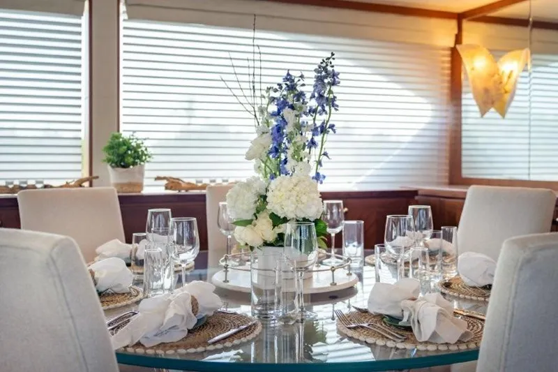 Slide: The Image of Elegant dining setup on 2017 Ocean Alexander Motor Yacht with floral centerpiece. - 31