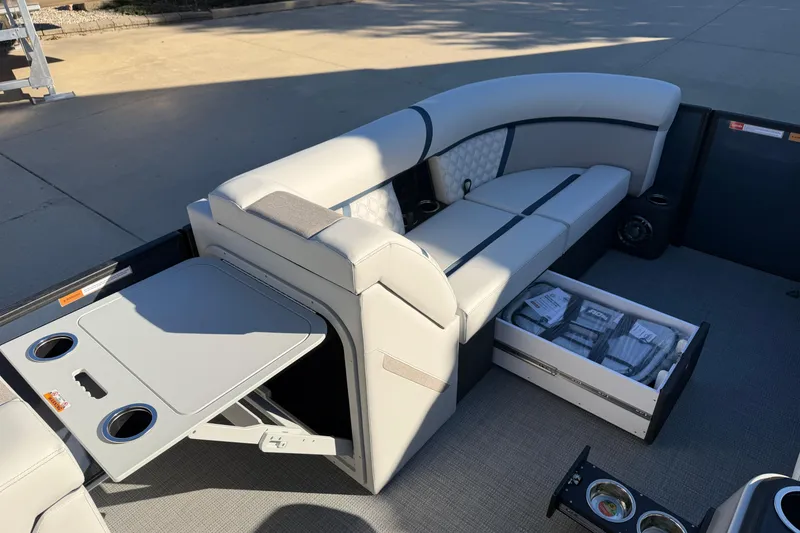 Slide: The Image of 2026 Crest Conquest 230 L pontoon boat interior with seating and control panel. - 12