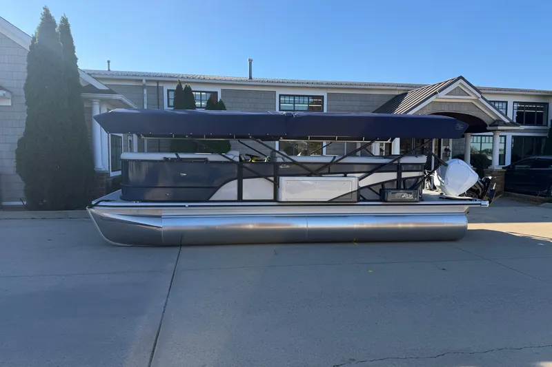Slide: The Image of 2026 Crest Conquest 230 L pontoon boat parked outside a modern house. - 3