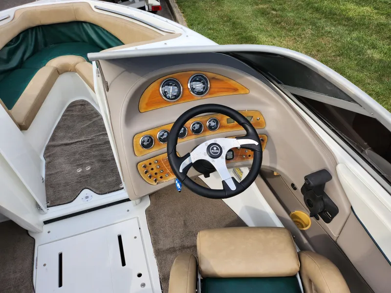 Slide: The Image of Interior of a 1998 Cobalt 200 boat with steering wheel and dashboard controls. - 12