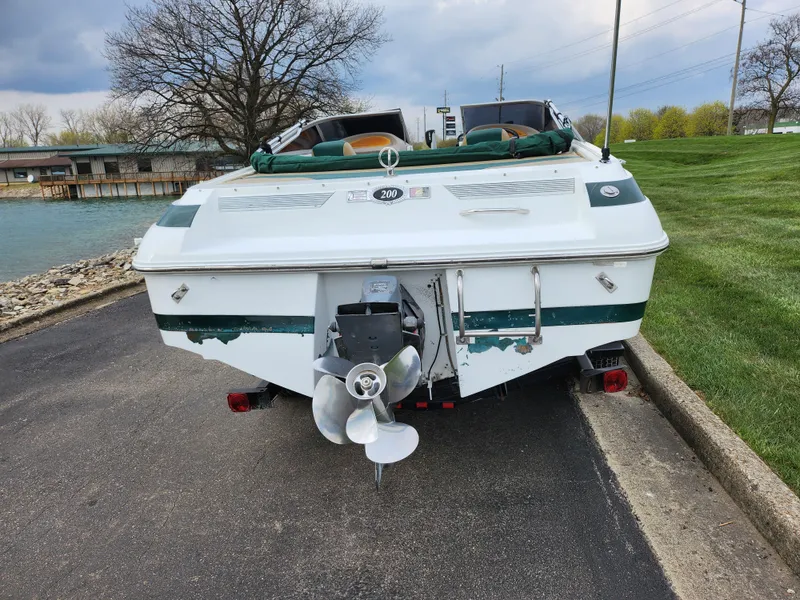 Slide: The Image of Rear view of a 1998 Cobalt 200 boat parked near a lake. - 2