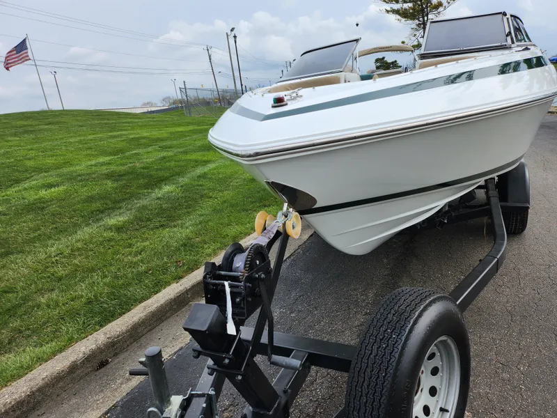 Slide: The Image of 1998 Cobalt 200 boat on trailer, parked on paved road near grassy area. - 6