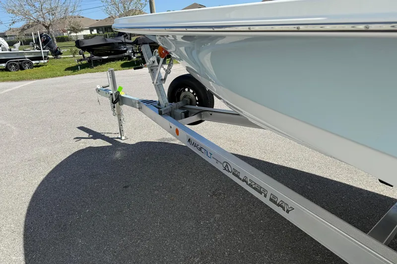 Slide: The Image of 2026 Blazer 2550 GTS boat on trailer, parked outdoors in sunny setting. - 13