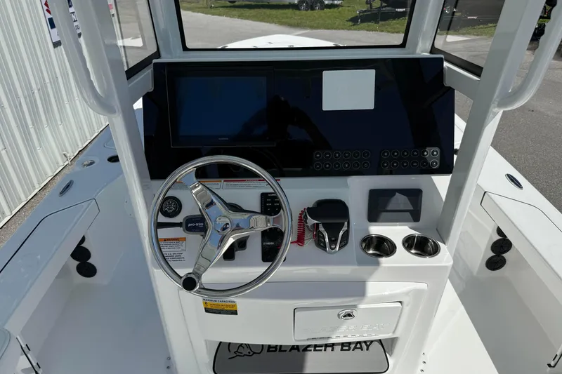 Slide: The Image of 2026 Blazer 2550 GTS boat console with steering wheel, controls, and cup holders. - 19