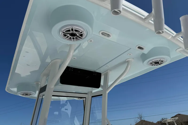 Slide: The Image of 2026 Blazer 2550 GTS boat roof with speakers and rod holders against blue sky. - 26