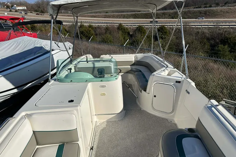 Slide: The Image of 1998 Bayliner 2659 Rendezvous boat interior with seating and helm, parked outdoors. - 11