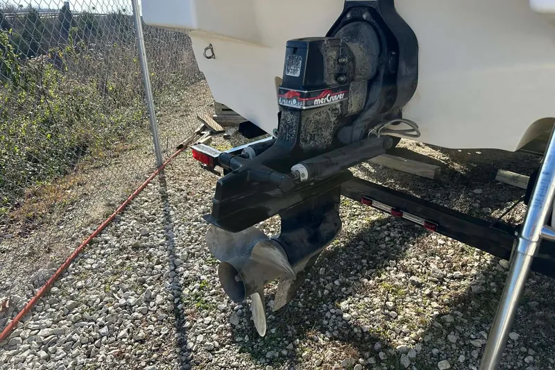 Slide: The Image of 1998 Bayliner 2659 Rendezvous boat with MerCruiser outdrive on gravel surface. - 4