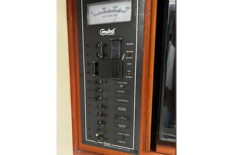 Slide: The Image of Electrical panel of a 2005 Carolina Classic 28 boat, featuring AC voltage meter and switches. - 12