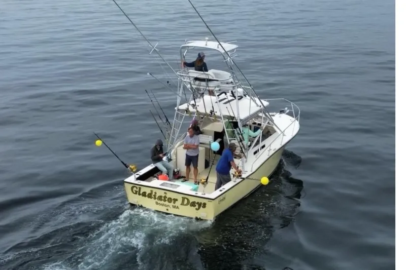 Slide: The Image of 2005 Carolina Classic 28 boat, "Gladiator Days," with people fishing in open water. - 3