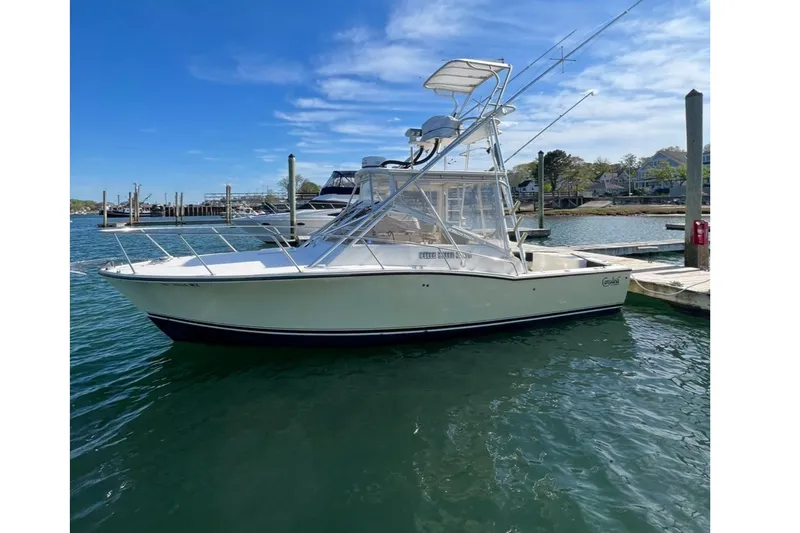 Slide: The Image of 2005 Carolina Classic 28 boat docked in a marina under a clear blue sky. - 4