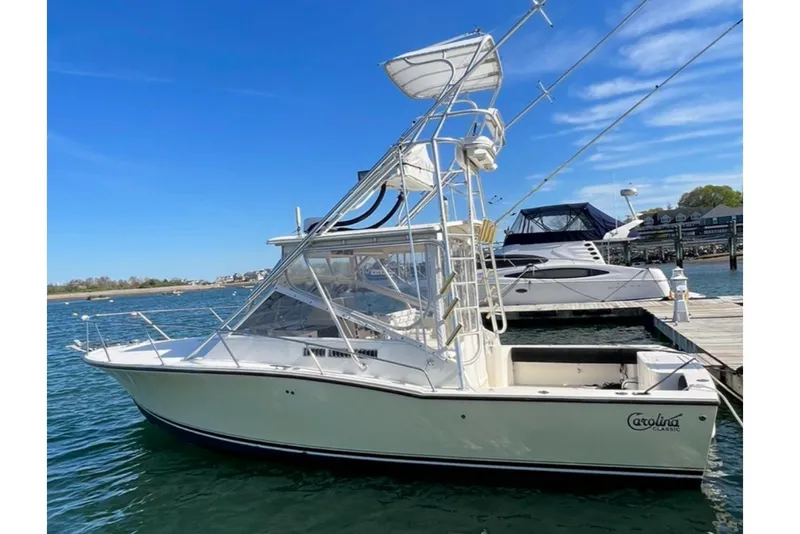 Slide: The Image of 2005 Carolina Classic 28 boat docked in a marina under clear blue skies. - 5