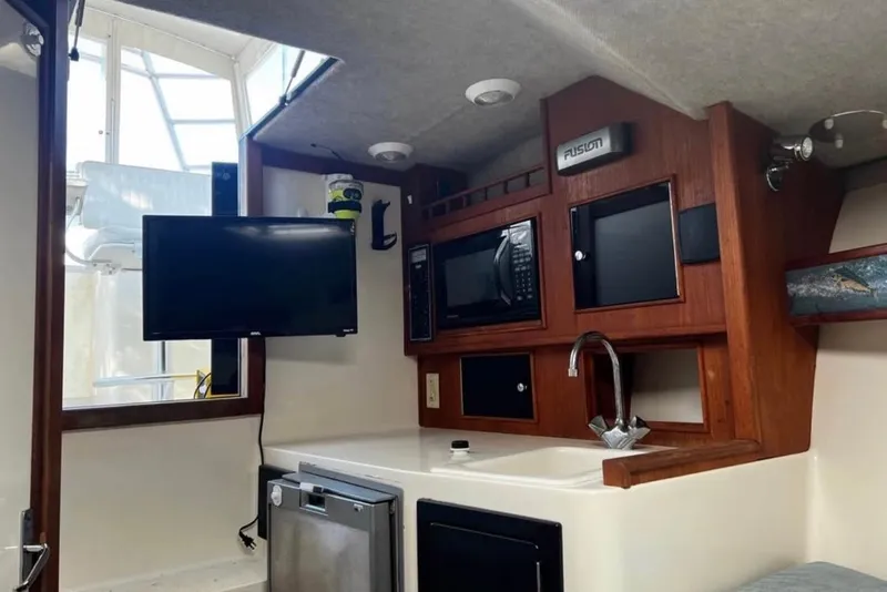 Slide: The Image of Interior of a 2005 Carolina Classic 28 boat with TV, microwave, and sink. - 7